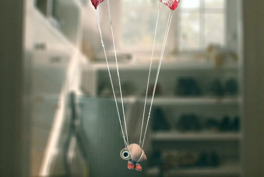 An image from an short film showing a toy dangling from strings, presumably balloon structure.