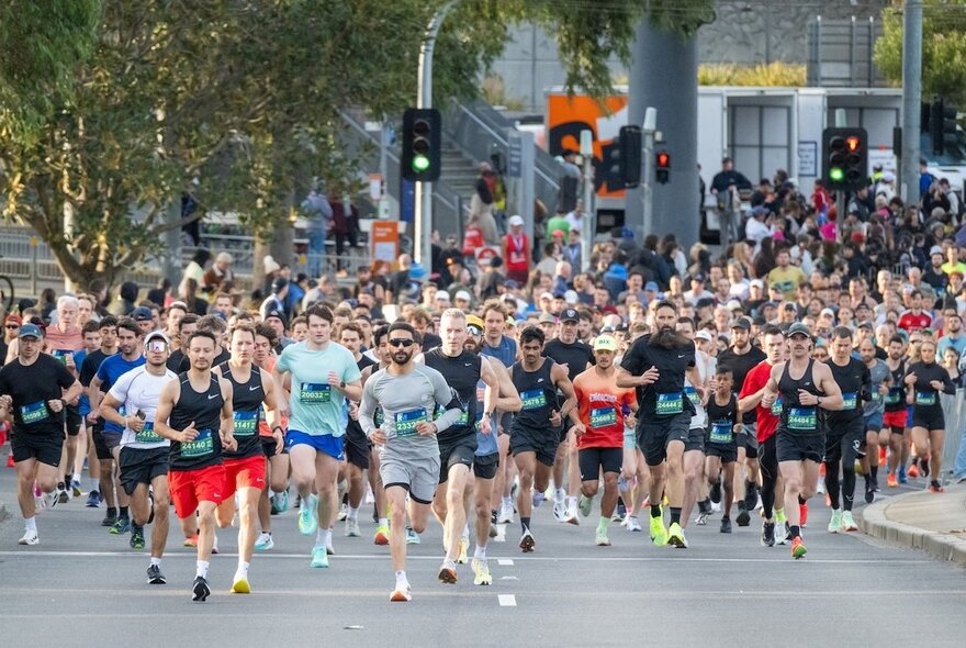 A huge crowd of runners participating in an organised running event through the streets of Melbourne.