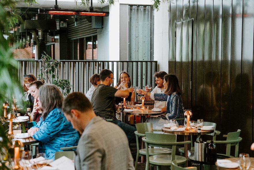 People seated in a large atrium-style outdoor section of a restaurant.