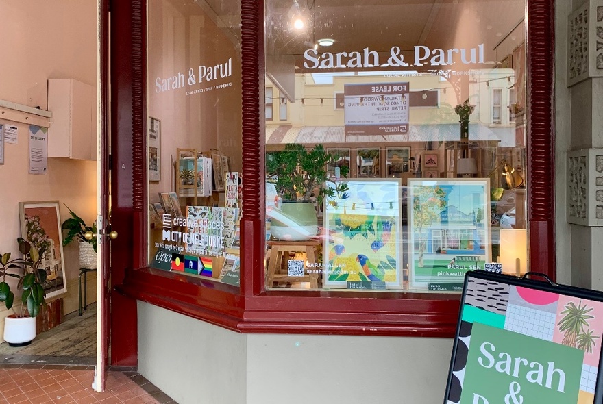 The exterior of a gift shop showing the window display, with an open door leading into the retail space.