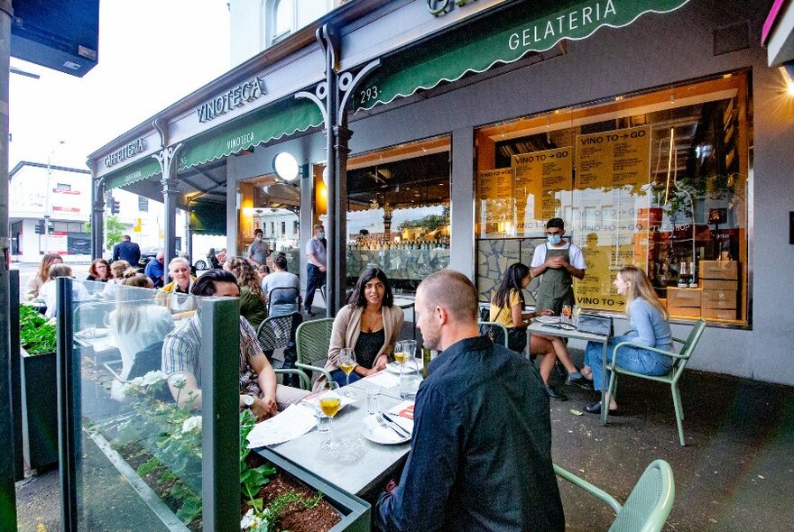 People sitting at cafe tables outside King and Godfree.