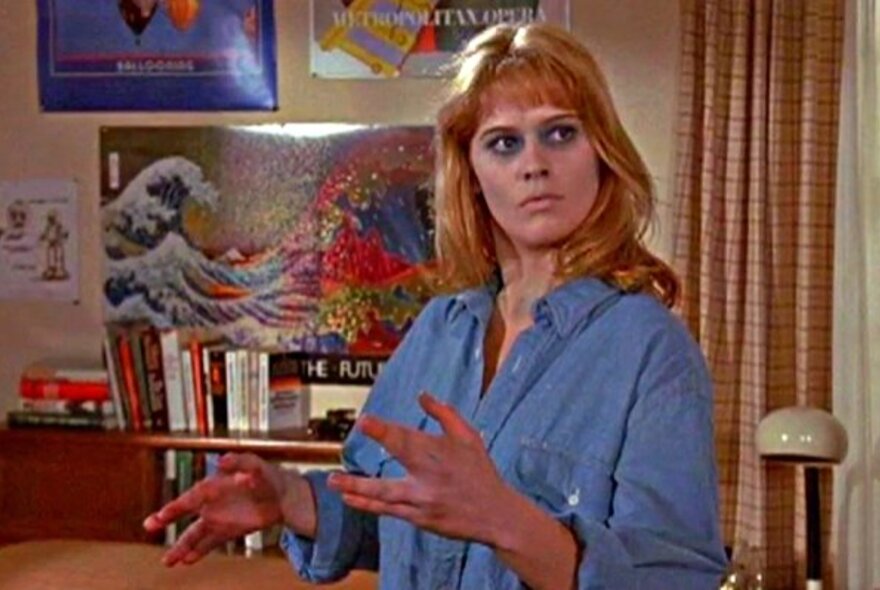 A still from a film showing a woman in an early 1970s apartment setting.
