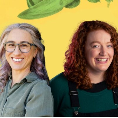 Two women laughing against a yellow background with painted green foliage.