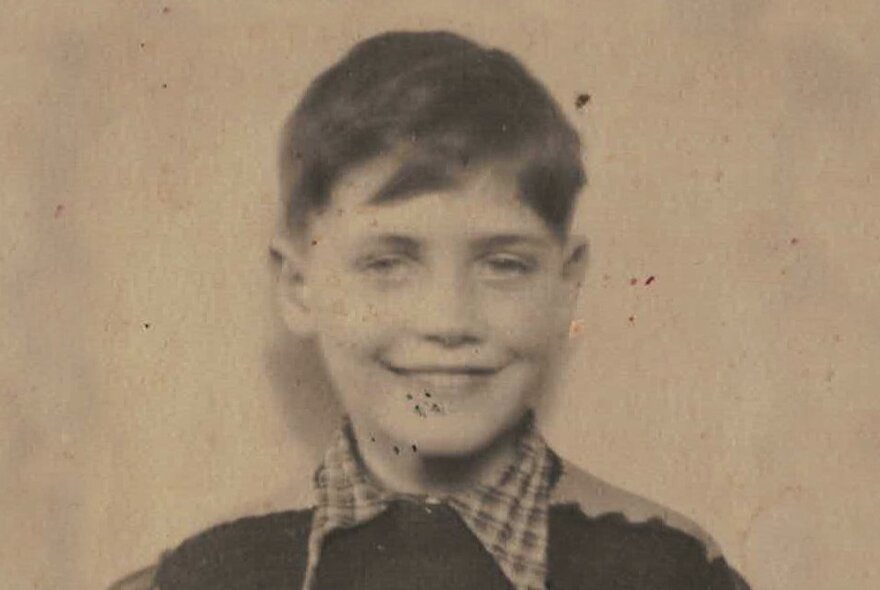 A black and white photograph of a smiling boy aged approximately 8 or 9, dating from the early 1950s.