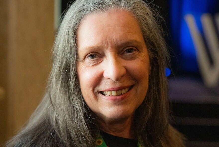 Portrait of Writers Victoria Ceo, Julie Skate, smiling at the camera with a blurred background.