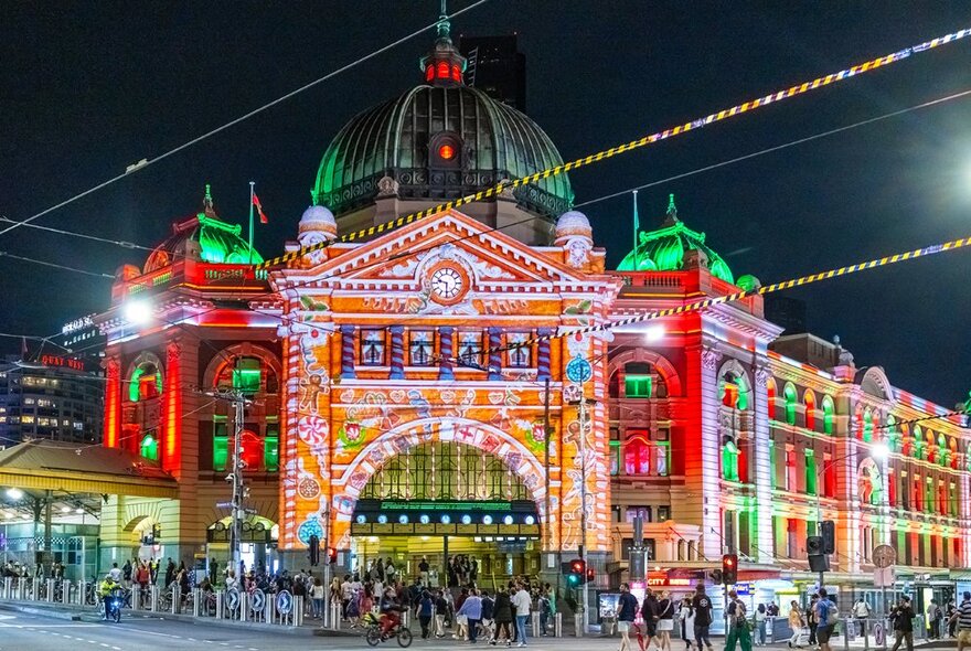 Flinders Street Station facade illuminated with gingerbread themed projections and red and green lighting treatment.