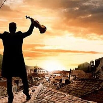 Poster for the 1971 musical film Fiddler on the Roof features the main character silhouetted on a roof against a sunset while holding a violin.