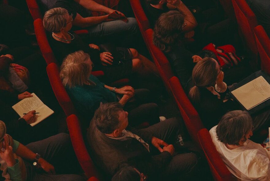 A seated audience in an auditorium, seen from above.