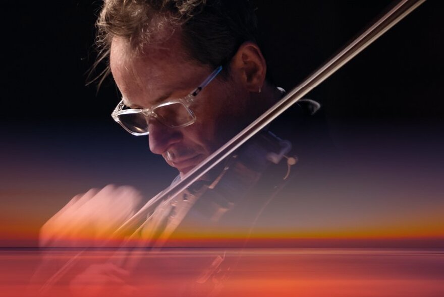 A musician playing a violin, with an overlay of a sunset over the Australian outback.