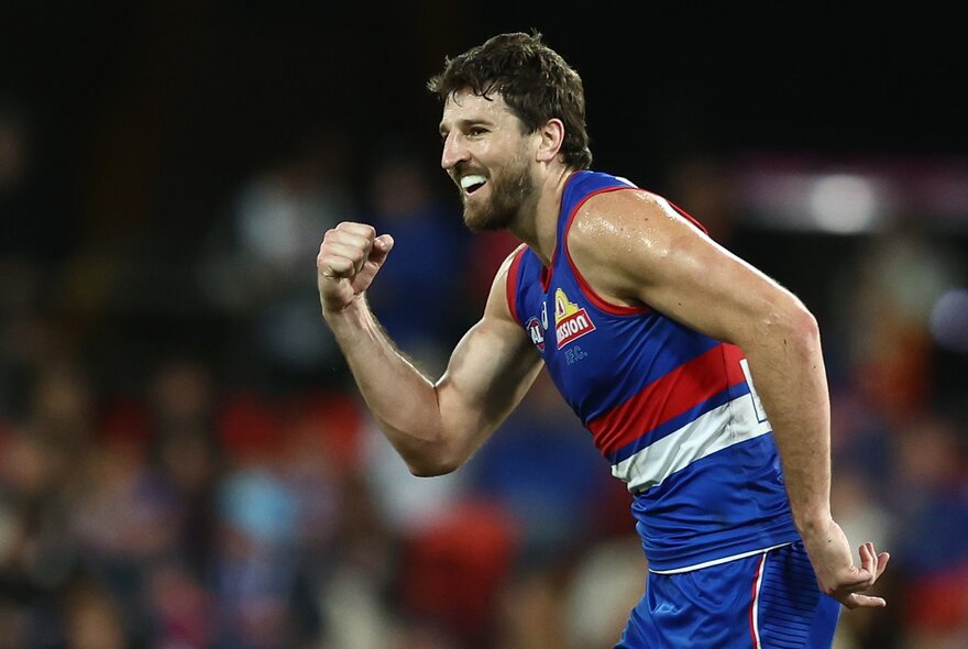 A Western Bulldogs AFL player looking pleased, with his fist clenched in front of his chest. 