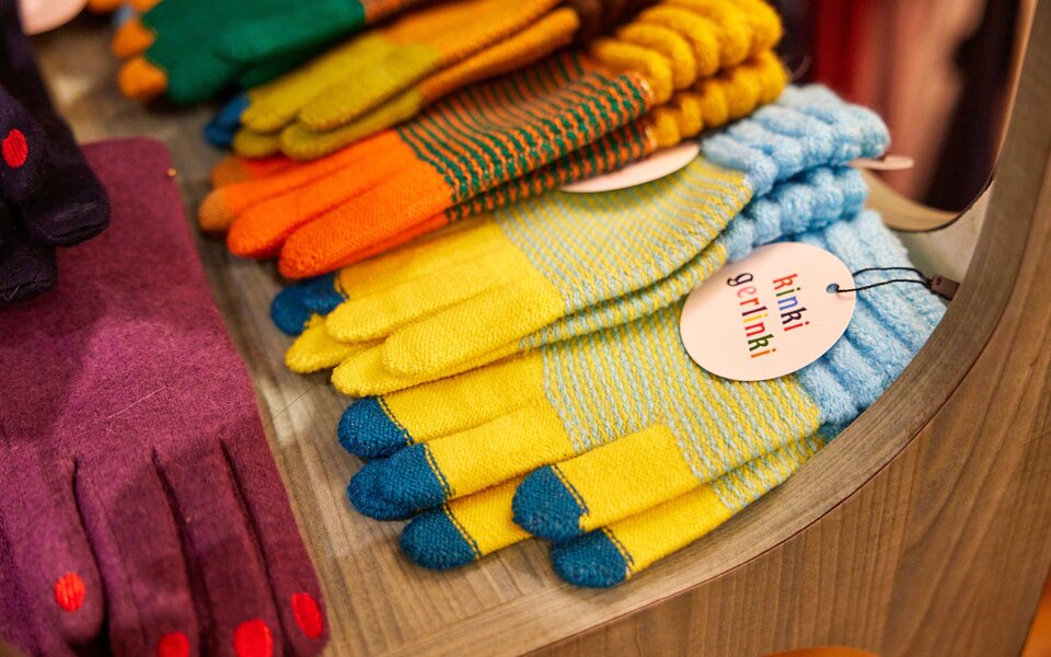 Colourful gloves displayed on a table in a shop