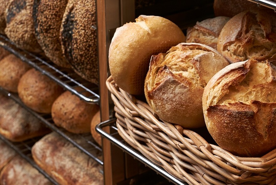 Shelves and baskets loaded with bread and rolls.