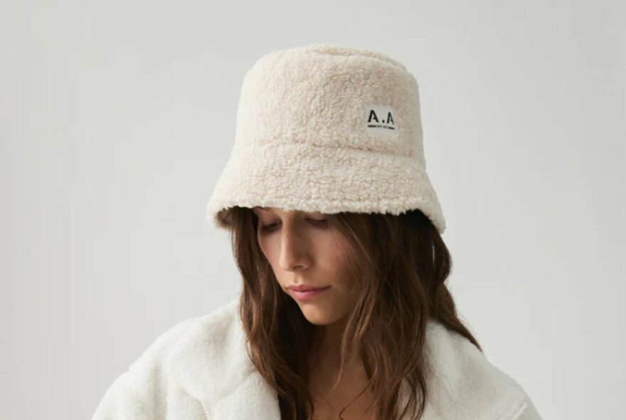 A model wearing a fluffy white bucket hat.