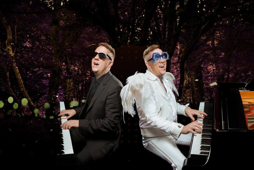 Two performers dressed as Billy Joel and Elton John, sitting back to back at two pianos.