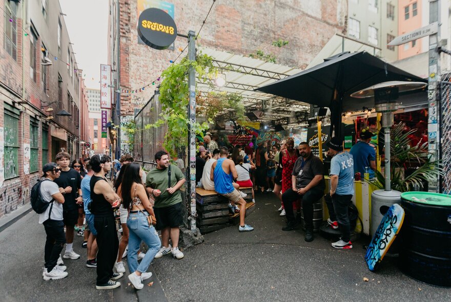 People gathered in the laneway around Section 8 during the day. 