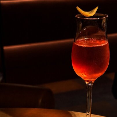 A small negroni with orange peel garnish. 