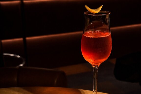 A small negroni with orange peel garnish. 