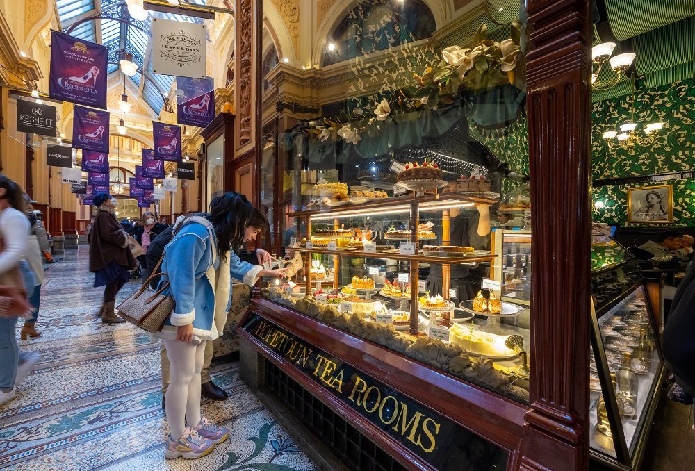 A couple looking at a window display of cakes.