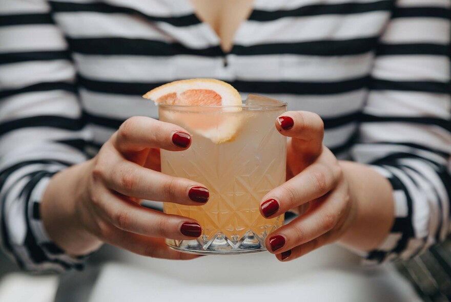 Slice of orange in an orange-coloured drink.