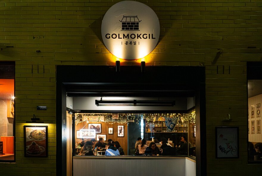 Dimly lit restaurant interior with booth and table seating.