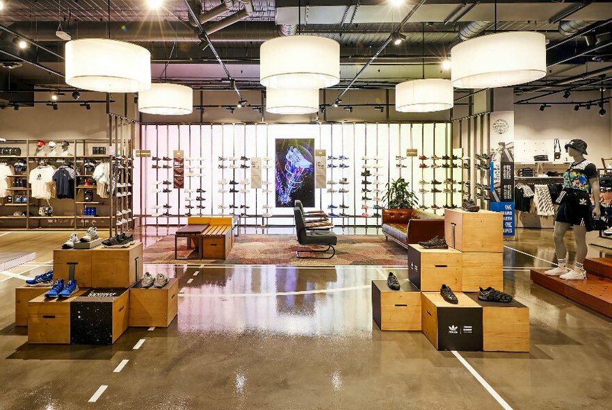 Interior of the Adidas store with clothing and a wall of shoes