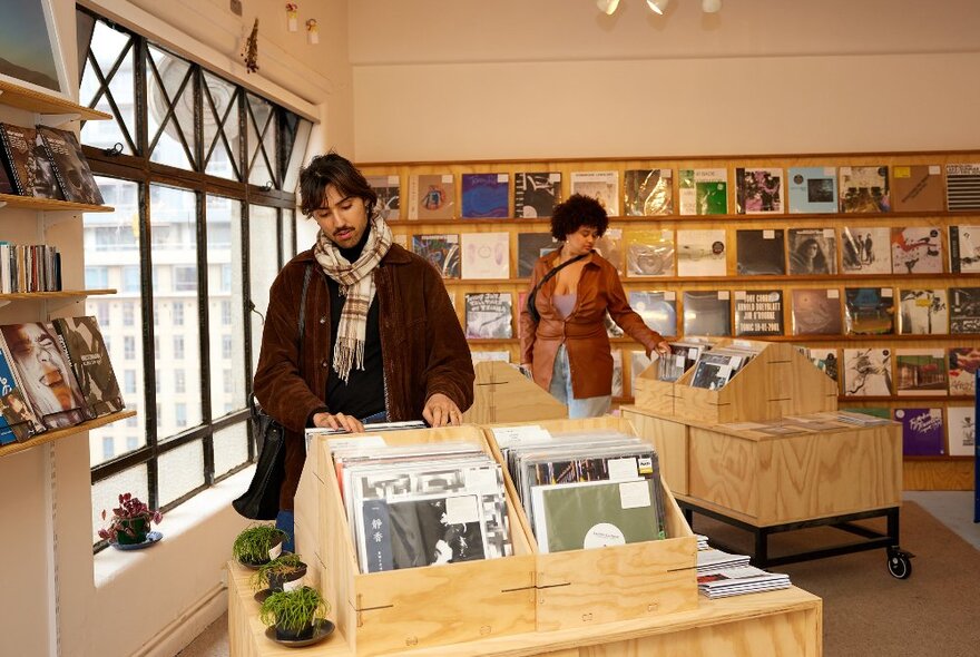 Two friends are browsing through records.