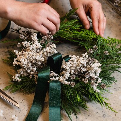 Person making a festive wreath.