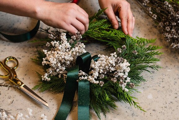 Person making a festive wreath.