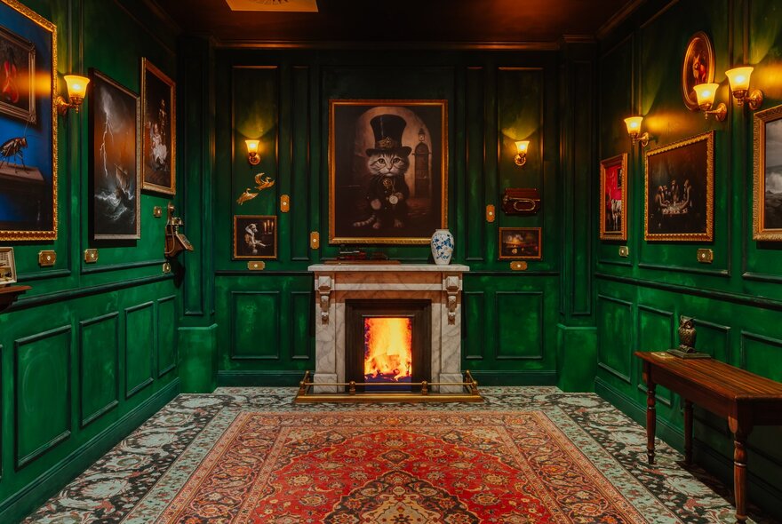 A green painted room with intricate wainscoting, a persian rug, artwork on every panel and wall sconces.