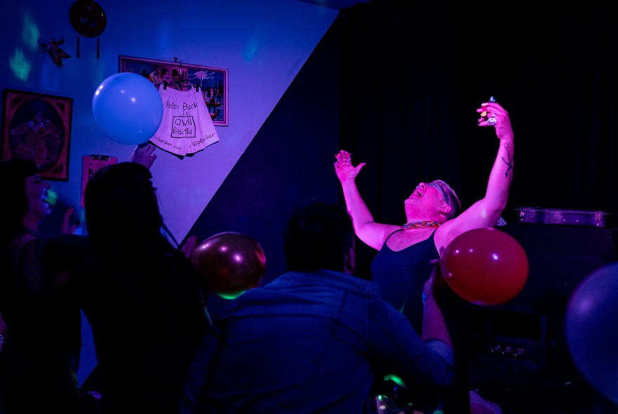 Peter Baecker performing and holding a red balloon