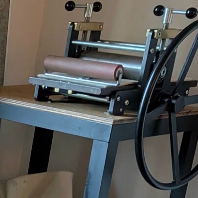 A screen printing press on a wooden table.