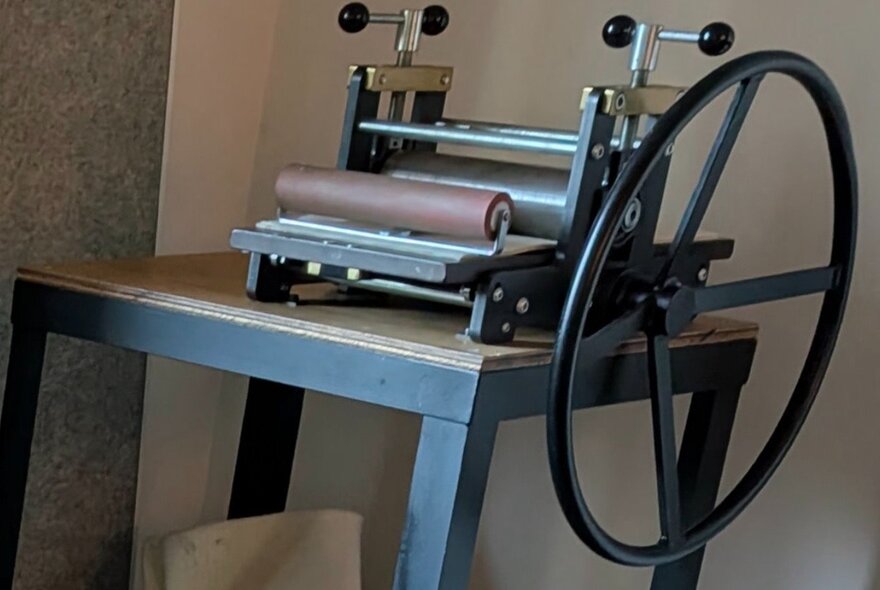 A screen printing press on a wooden table.