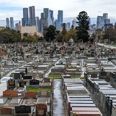 Melbourne Cemetery with graves in foreground and city buildings in the background.