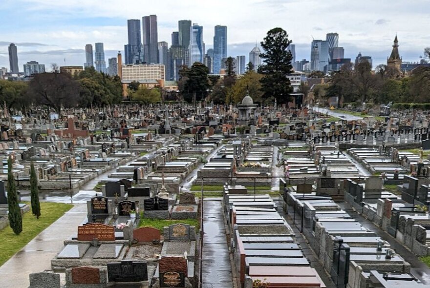 Melbourne Cemetery with graves in foreground and city buildings in the background.