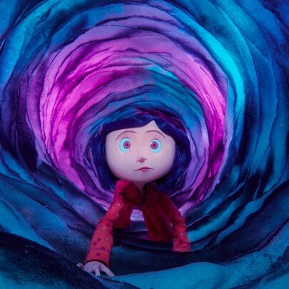 Still from the animation film Coraline, of a young girl with short blue hair and a red top crawling through a vibrant, spiralling tunnel made of swirling blue, purple, and bright pink layers.