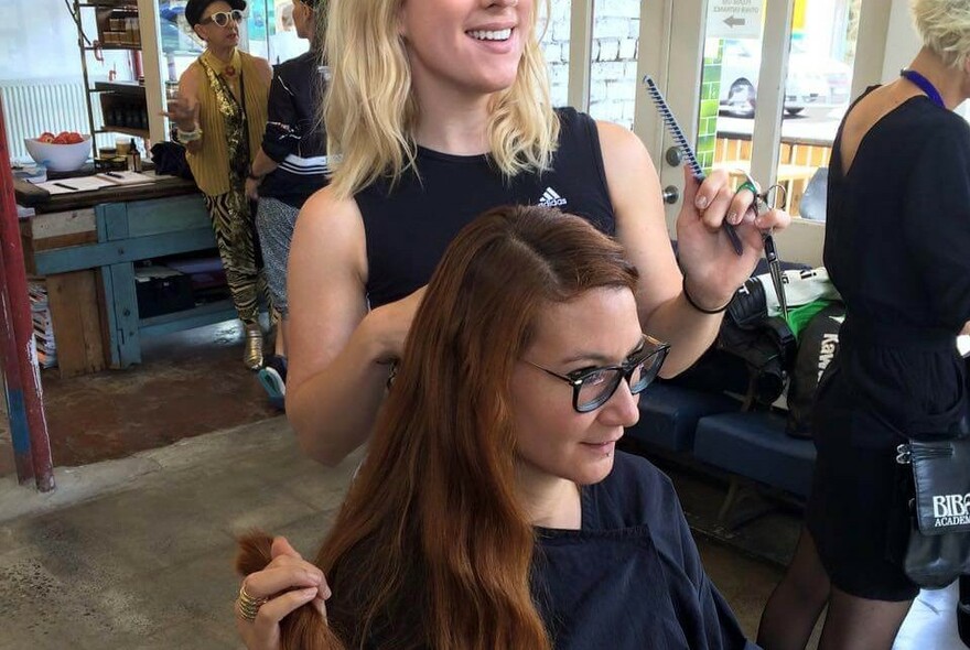 Hairdresser engaging with a client during a hair appointment. 