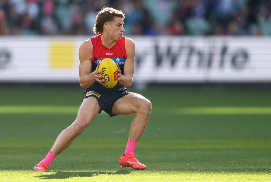 Melbourne  AFL football player with the ball during a match.