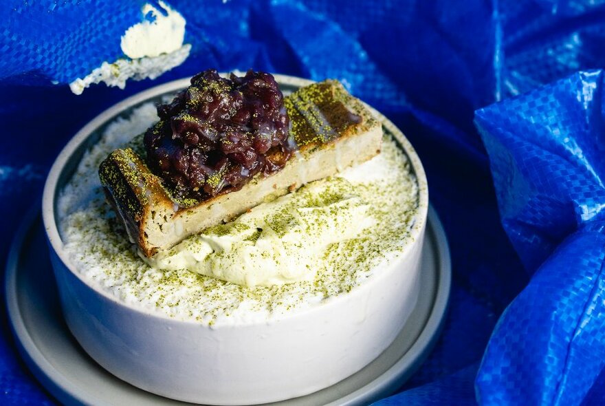 An elaborate dessert displayed on a blue tablecloth.