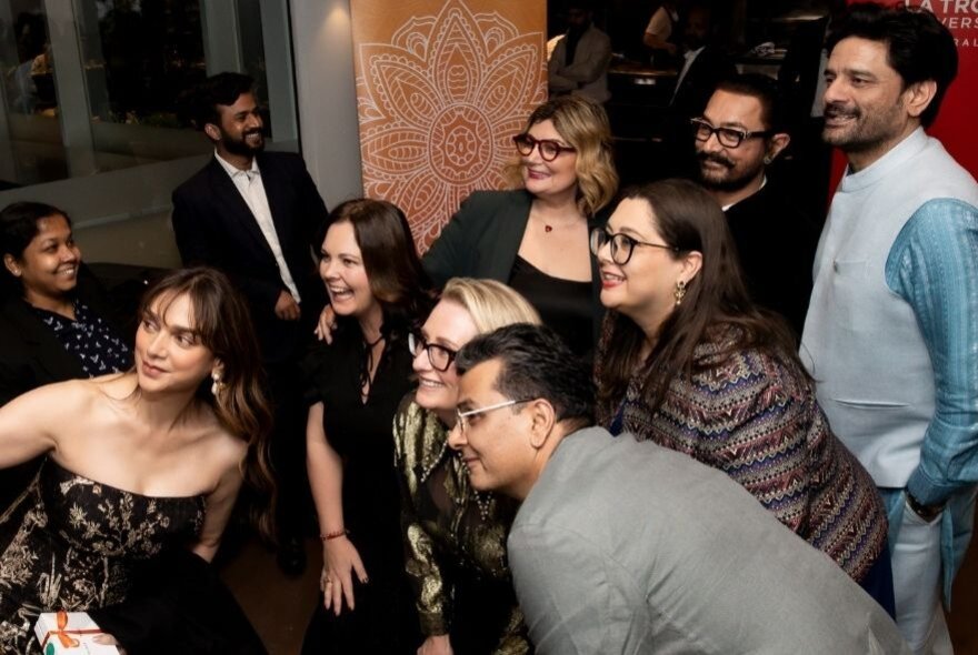 A group of people all looking at the same thing, some crouched down. 