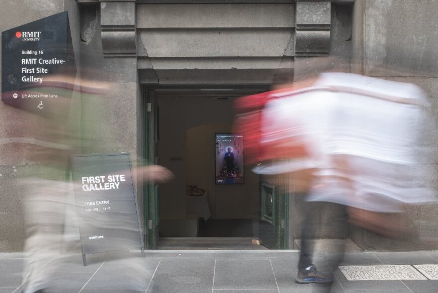 An Edwardian-style entrance with steps going down, with blurred people walking past.