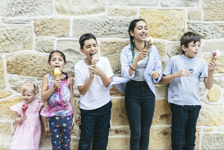 Row of kids enjoying ice creams.