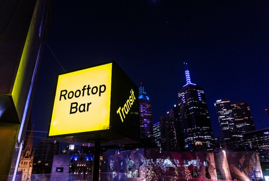 Cityscape view from rooftop bar at night.