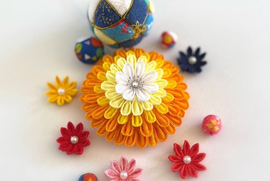 Brightly coloured objects that resemble flowers, made from small pieces of folded and sewn fabric.