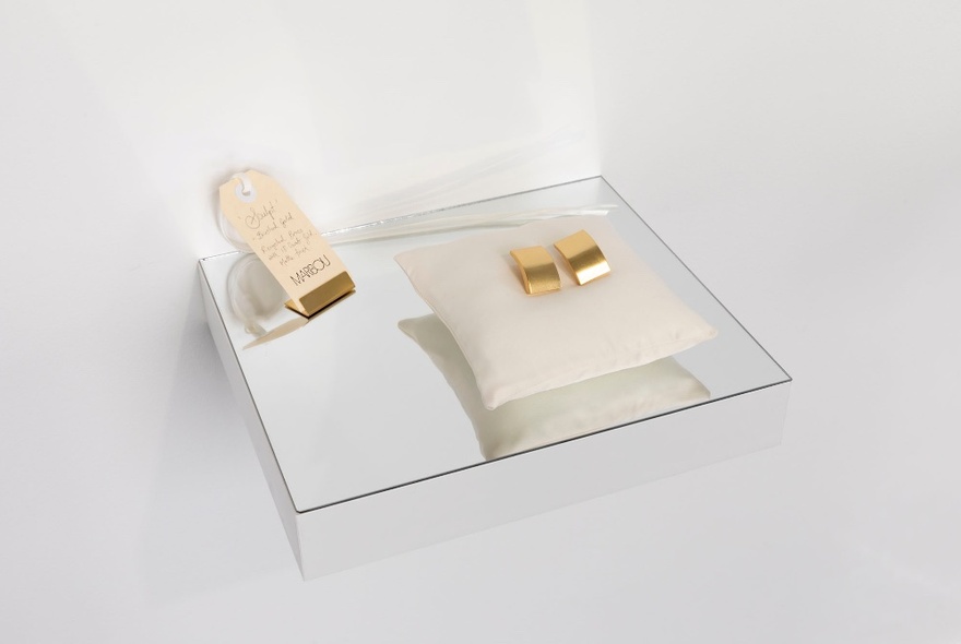 Gold earrings displayed on a white setting.
