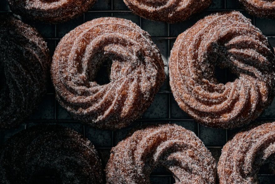 Cinnamon sugar crullers, made from deep-fried choux pastry piped into a fluted ring shape.