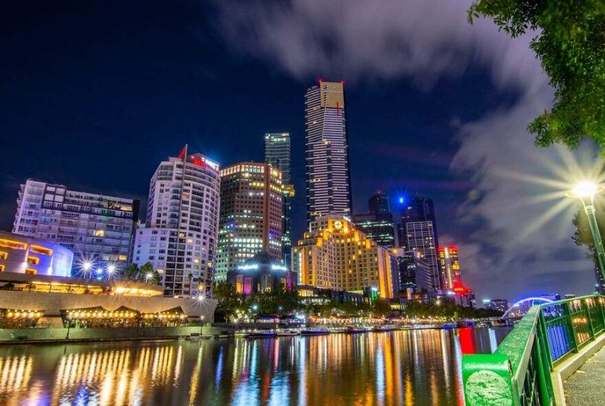 A city skyline at night next to a river