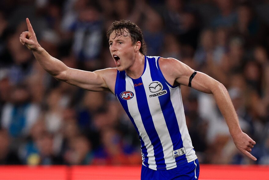 North Melbourne AFL football player gesticulating during a match.