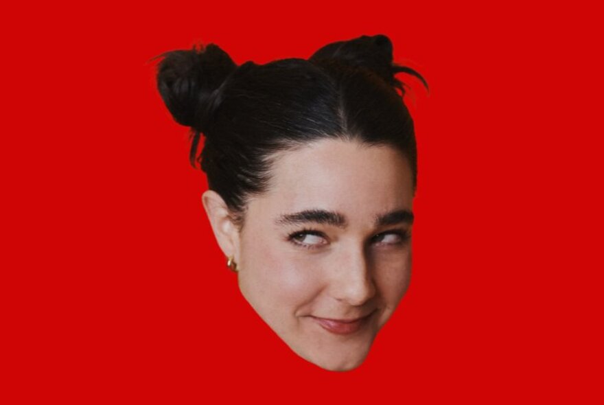 The floating head of comedian Lara Ricote against a bright red background, her eyes looking sideways and with a slight grin.