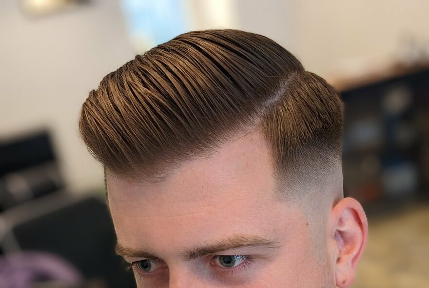 The top of a man's head showing freshly cut and styled hair,