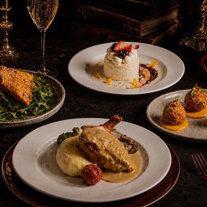 A table with four plates of entrees, main and dessert. 